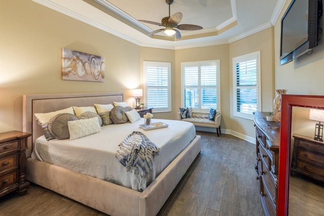 bedroom featuring a raised ceiling, crown molding, dark wood-type flooring, and ceiling fan