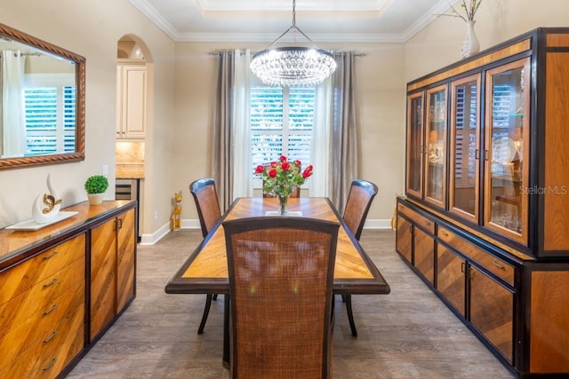 dining area featuring crown molding, a tray ceiling, dark hardwood / wood-style floors, and a chandelier