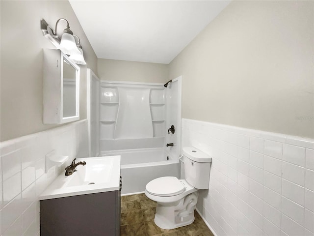 full bathroom featuring vanity,  shower combination, toilet, and tile walls