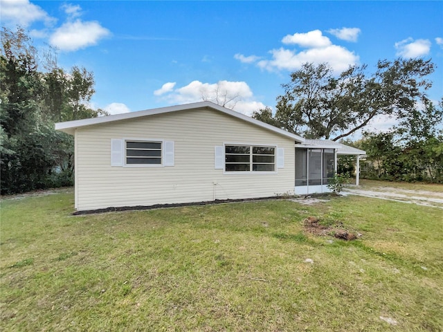 view of side of property featuring a yard and a sunroom