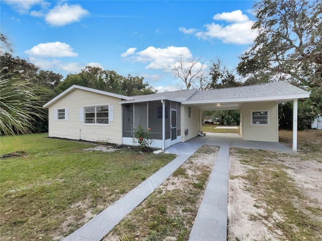 view of front of house featuring a front yard, a carport, and a sunroom