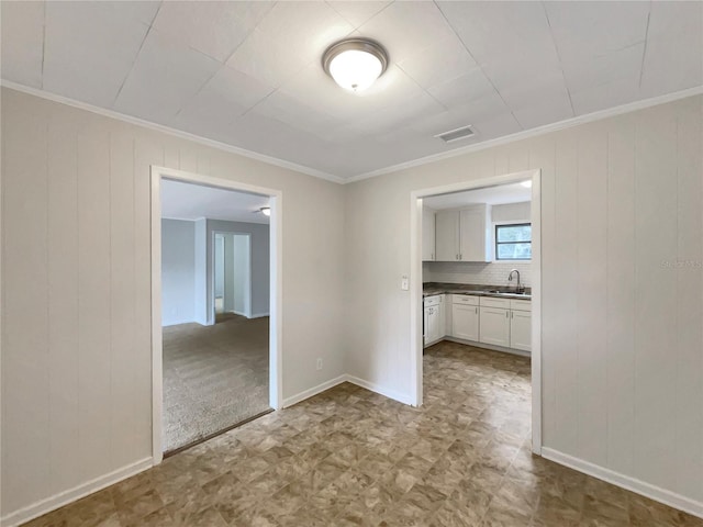 spare room featuring crown molding and sink