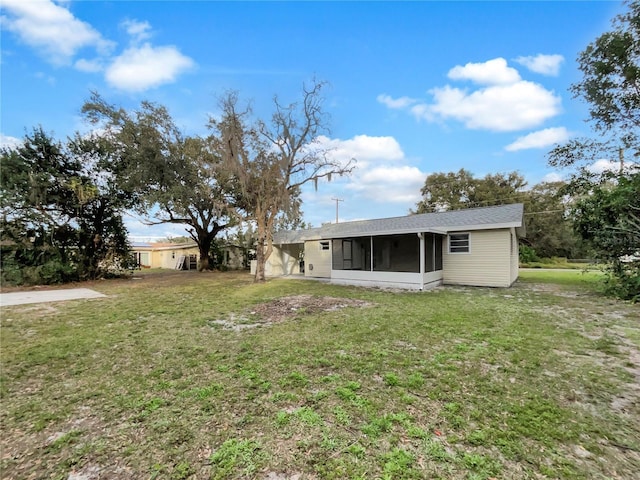 back of property with a yard and a sunroom