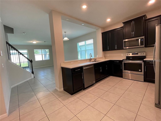 kitchen featuring light tile patterned flooring, stainless steel appliances, a wealth of natural light, and sink