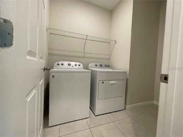 laundry room featuring washing machine and clothes dryer and light tile patterned flooring