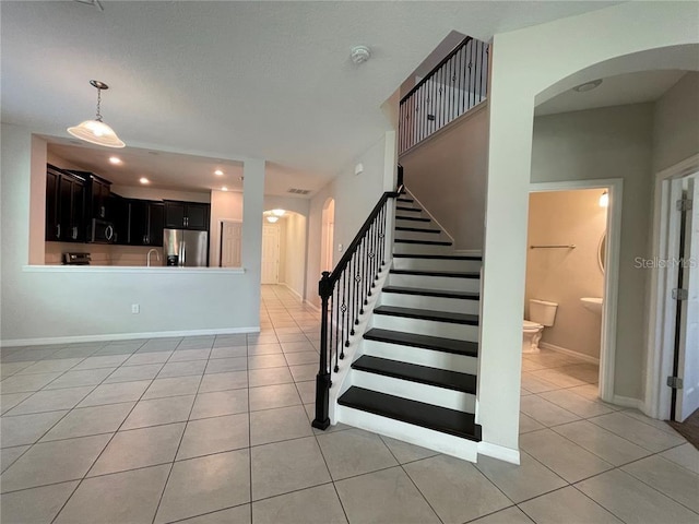 stairway with tile patterned flooring and sink