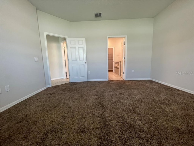 unfurnished bedroom with connected bathroom and light colored carpet