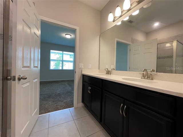 bathroom with tile patterned floors, vanity, and a shower with shower door