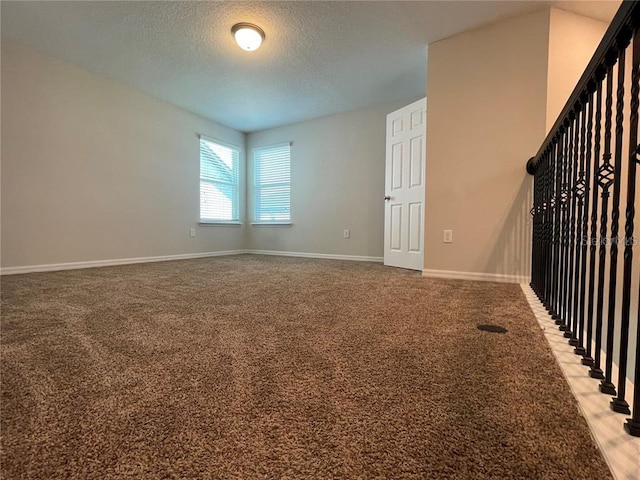 spare room featuring carpet flooring and a textured ceiling