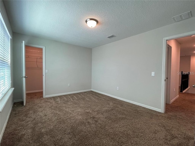 carpeted spare room featuring a textured ceiling