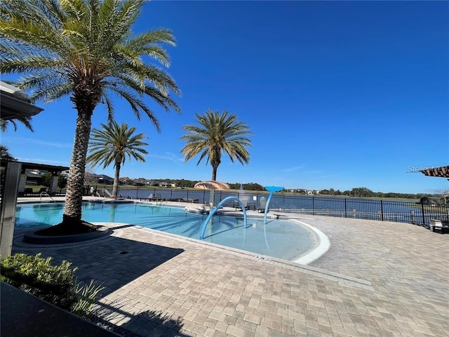 view of swimming pool with a patio and a water view