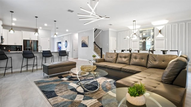 living room with sink, an inviting chandelier, crown molding, and light tile floors