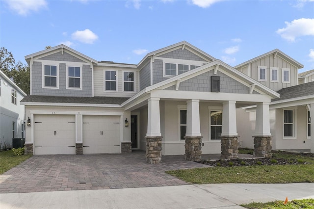 craftsman house with a porch, a garage, and central air condition unit