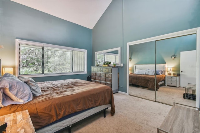 bedroom featuring high vaulted ceiling, a closet, and carpet floors