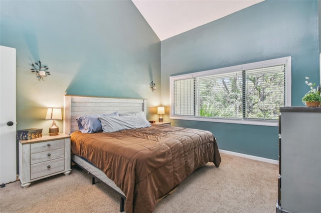 carpeted bedroom with high vaulted ceiling