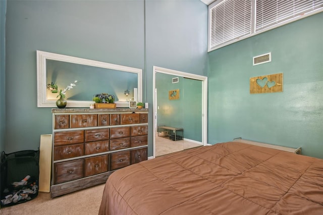 carpeted bedroom with a high ceiling