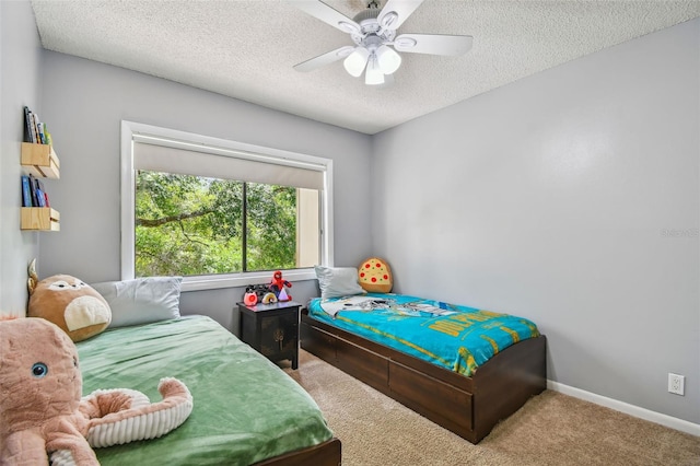 carpeted bedroom with ceiling fan and a textured ceiling