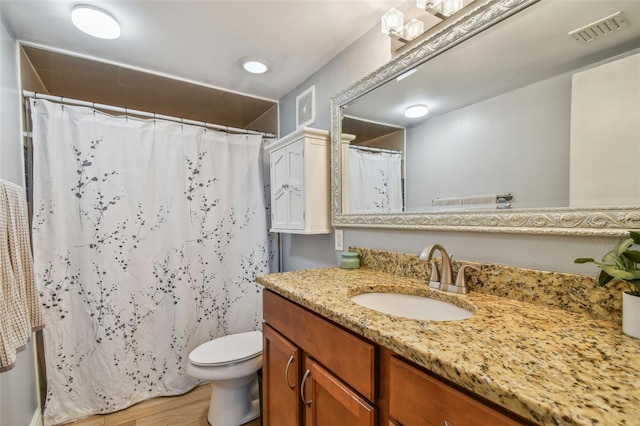 bathroom with oversized vanity, toilet, and wood-type flooring