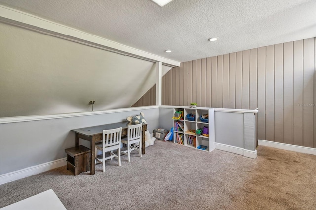 game room with a textured ceiling and carpet flooring