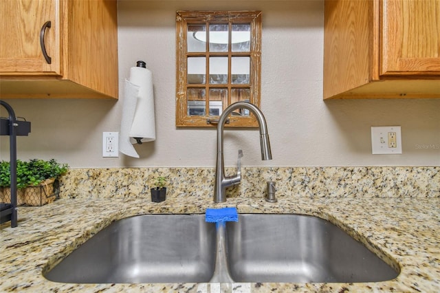 interior details with sink and light stone countertops