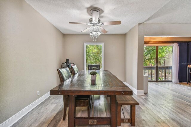 unfurnished dining area with a textured ceiling, ceiling fan, and hardwood / wood-style floors