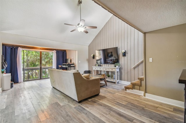 living room featuring high vaulted ceiling, hardwood / wood-style flooring, ceiling fan, and a textured ceiling