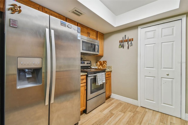 kitchen featuring light hardwood / wood-style flooring, stone countertops, and stainless steel appliances