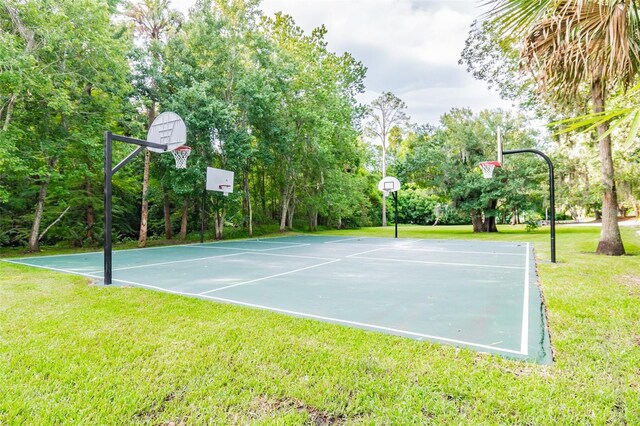 view of sport court featuring a lawn