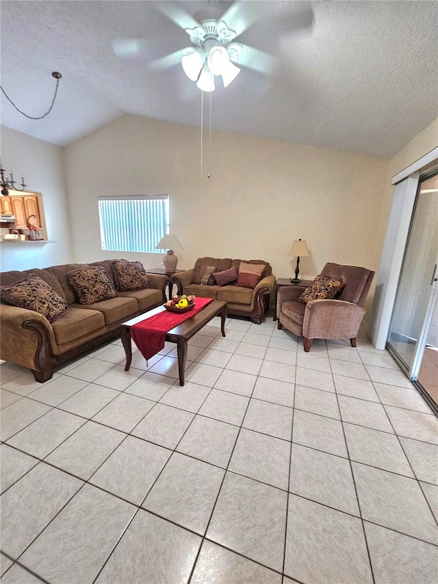 tiled living room with a textured ceiling, ceiling fan, and lofted ceiling