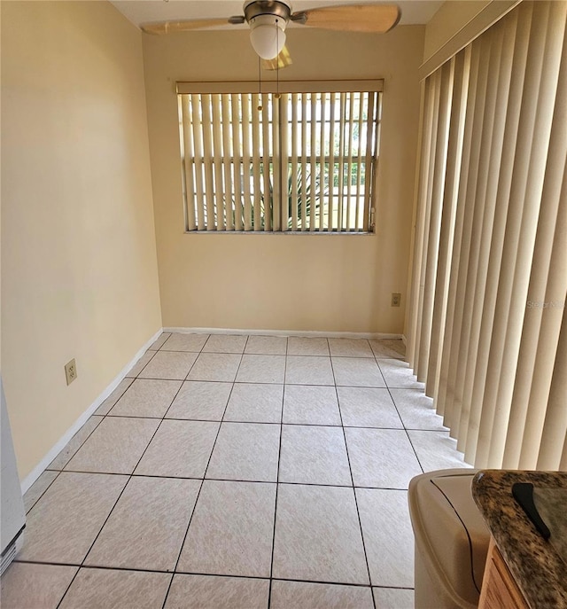 tiled spare room featuring ceiling fan