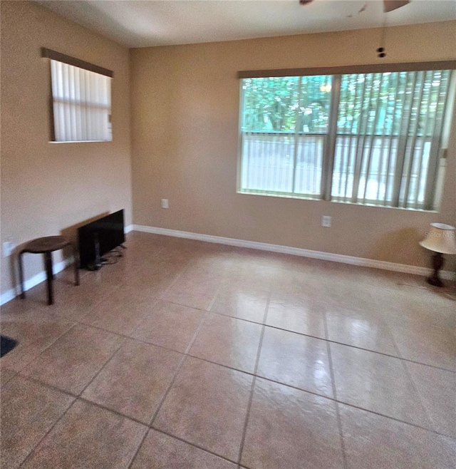 unfurnished living room with ceiling fan and light tile patterned floors