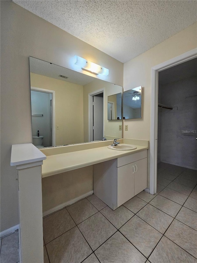 bathroom featuring tile patterned floors, vanity, and a textured ceiling