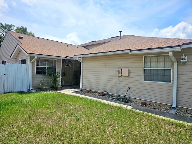 rear view of house featuring a yard