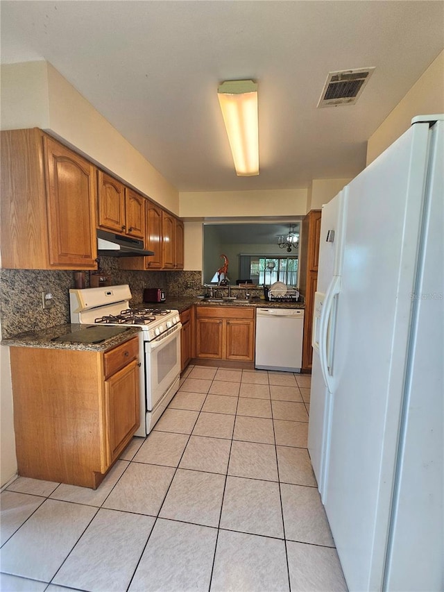 kitchen featuring tasteful backsplash, sink, light tile patterned floors, and white appliances