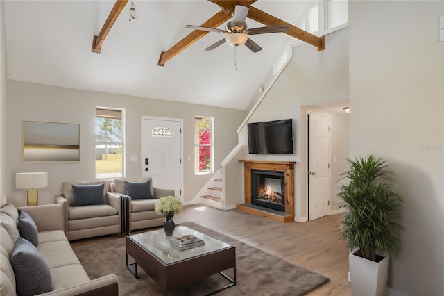 living room featuring beamed ceiling, high vaulted ceiling, wood-type flooring, and ceiling fan