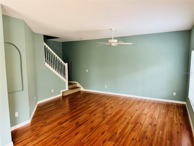 empty room featuring lofted ceiling, wood-type flooring, and ceiling fan