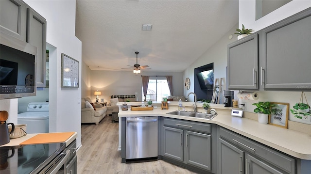 kitchen featuring gray cabinets, stainless steel appliances, kitchen peninsula, and sink