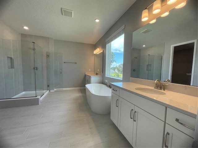 bathroom featuring hardwood / wood-style flooring, vanity, independent shower and bath, and a textured ceiling