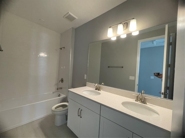 full bathroom with hardwood / wood-style flooring, vanity, washtub / shower combination, and toilet