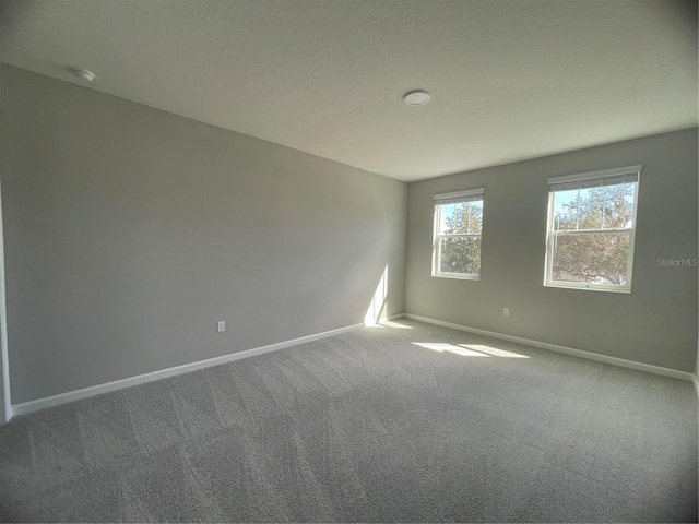 carpeted empty room featuring a textured ceiling