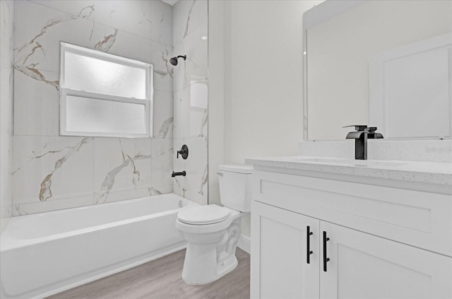 full bathroom with toilet, tiled shower / bath combo, wood-type flooring, and vanity