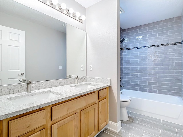 full bathroom featuring tile patterned floors, tiled shower / bath combo, toilet, and double sink vanity