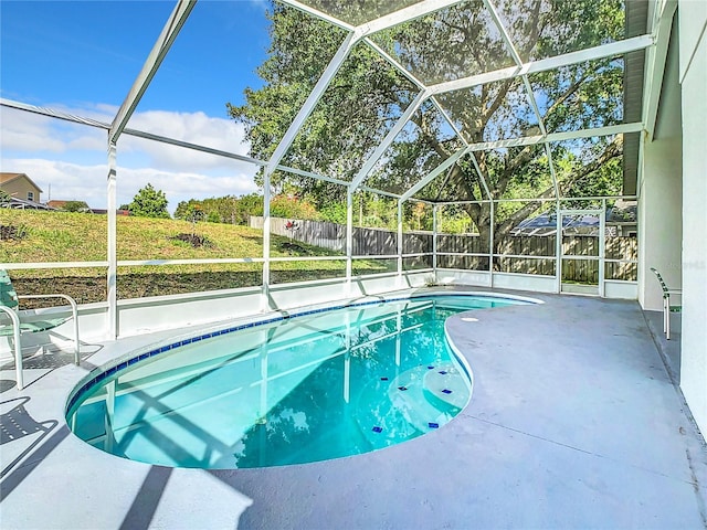 view of pool with a patio area and glass enclosure