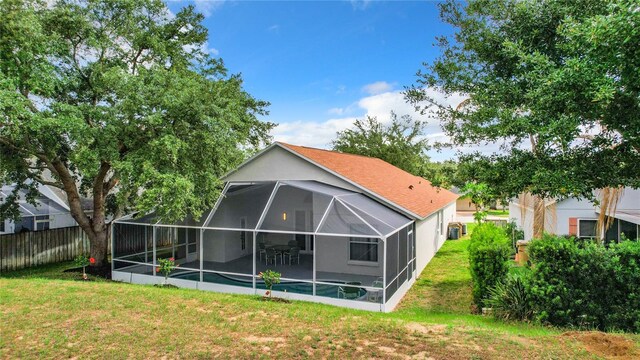 rear view of house featuring a yard and a lanai