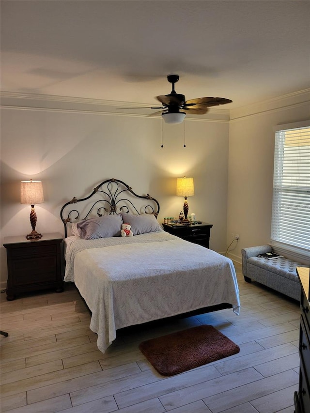 bedroom with hardwood / wood-style flooring, ceiling fan, and crown molding