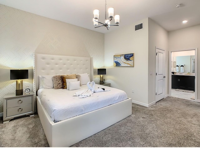 carpeted bedroom featuring ensuite bathroom and a chandelier