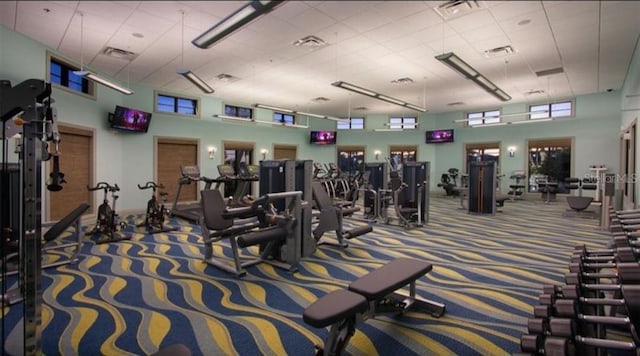 gym featuring carpet floors and a high ceiling