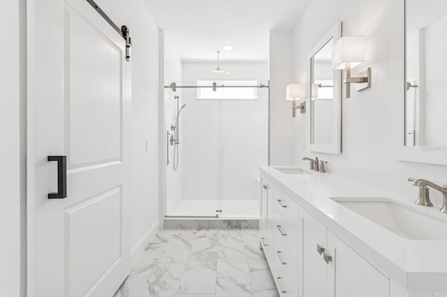 full bath with double vanity, marble finish floor, a stall shower, and a sink