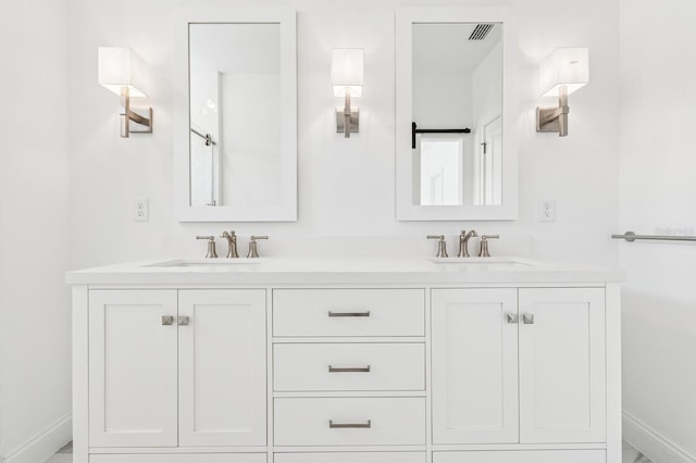 full bath with double vanity, visible vents, baseboards, and a sink