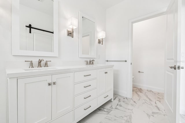 full bathroom featuring a sink, baseboards, marble finish floor, and double vanity